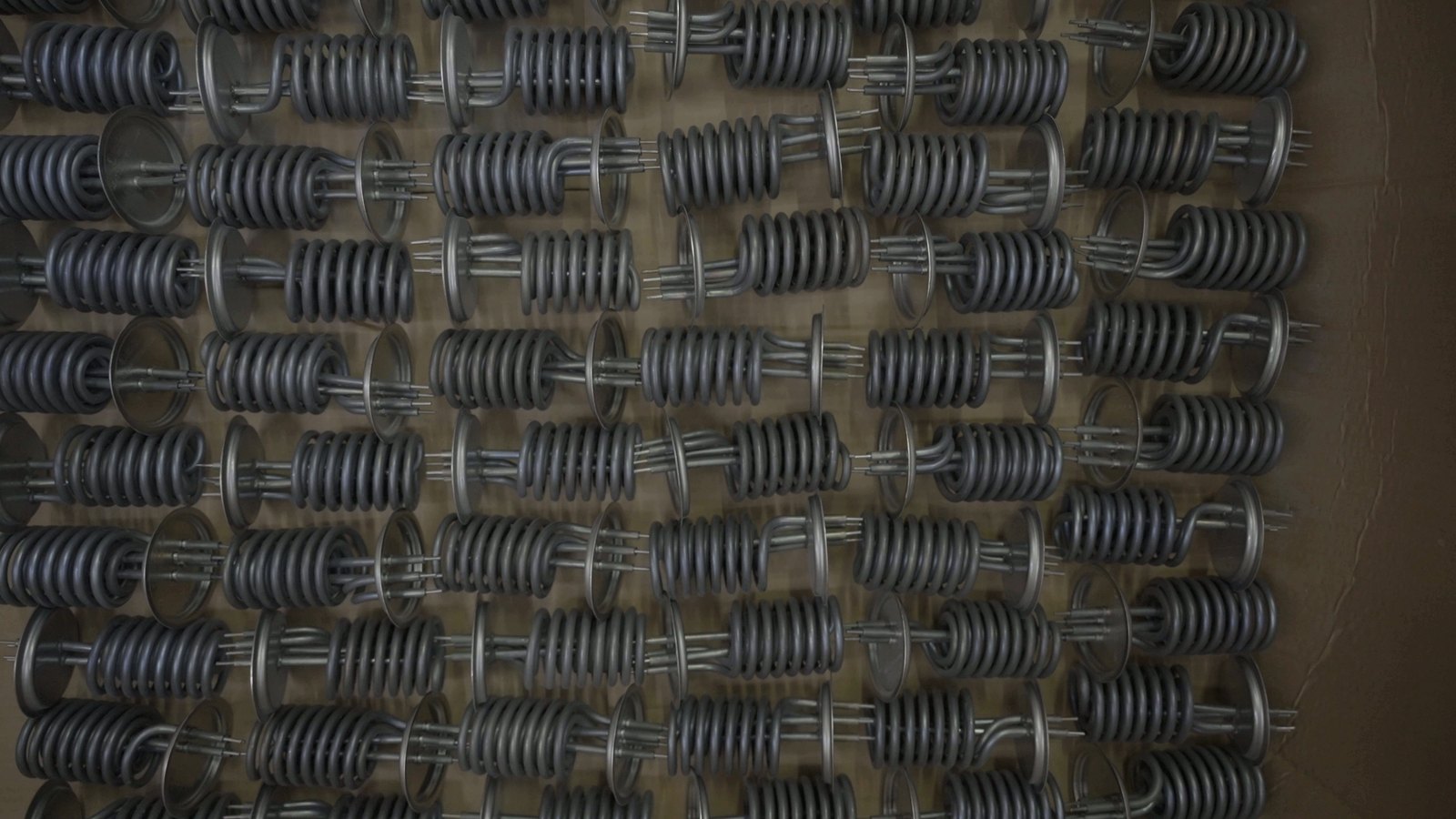 Coiled flange heating elements for water heaters on a display board