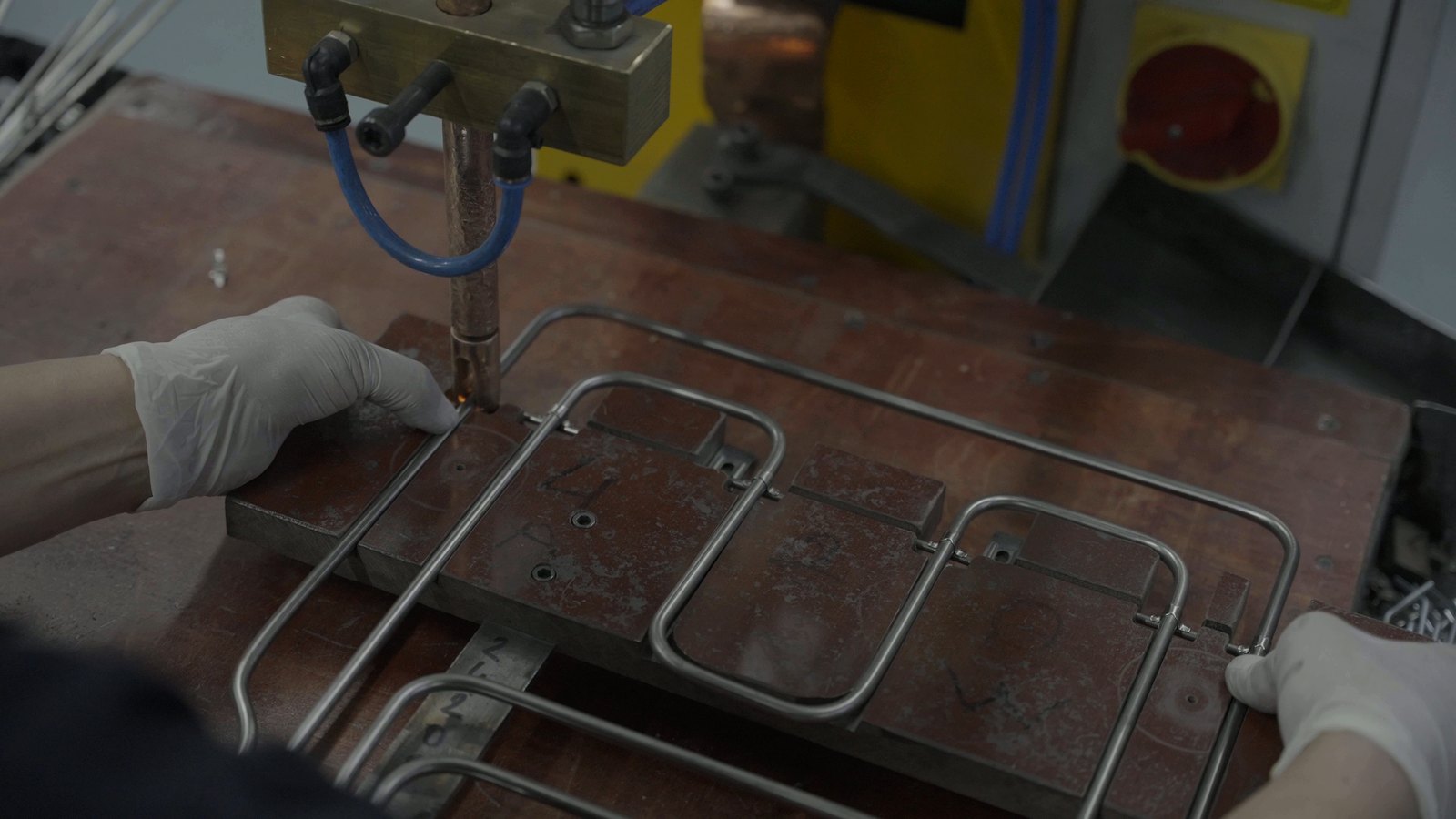 Welding a mounting bracket onto an oven heating element in a fixture