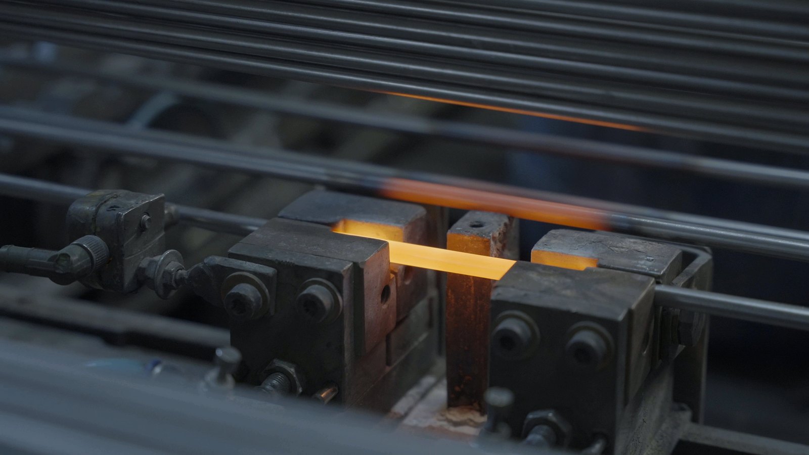 Section of a tube glowing red inside an induction coil during heat treatment