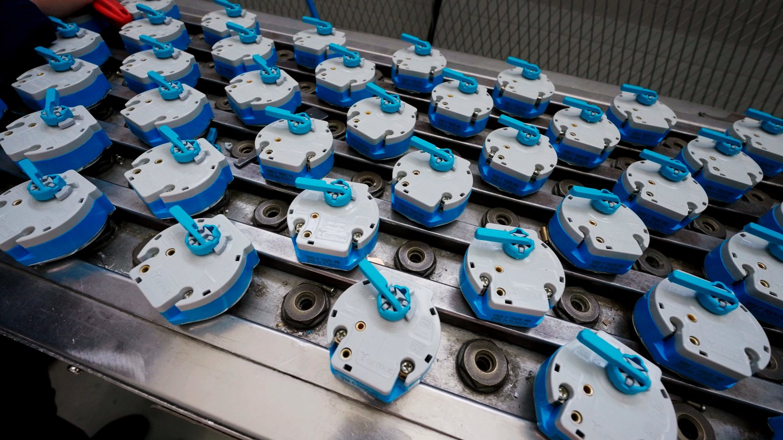 Rows of Tormec thermostat housings on assembly fixtures